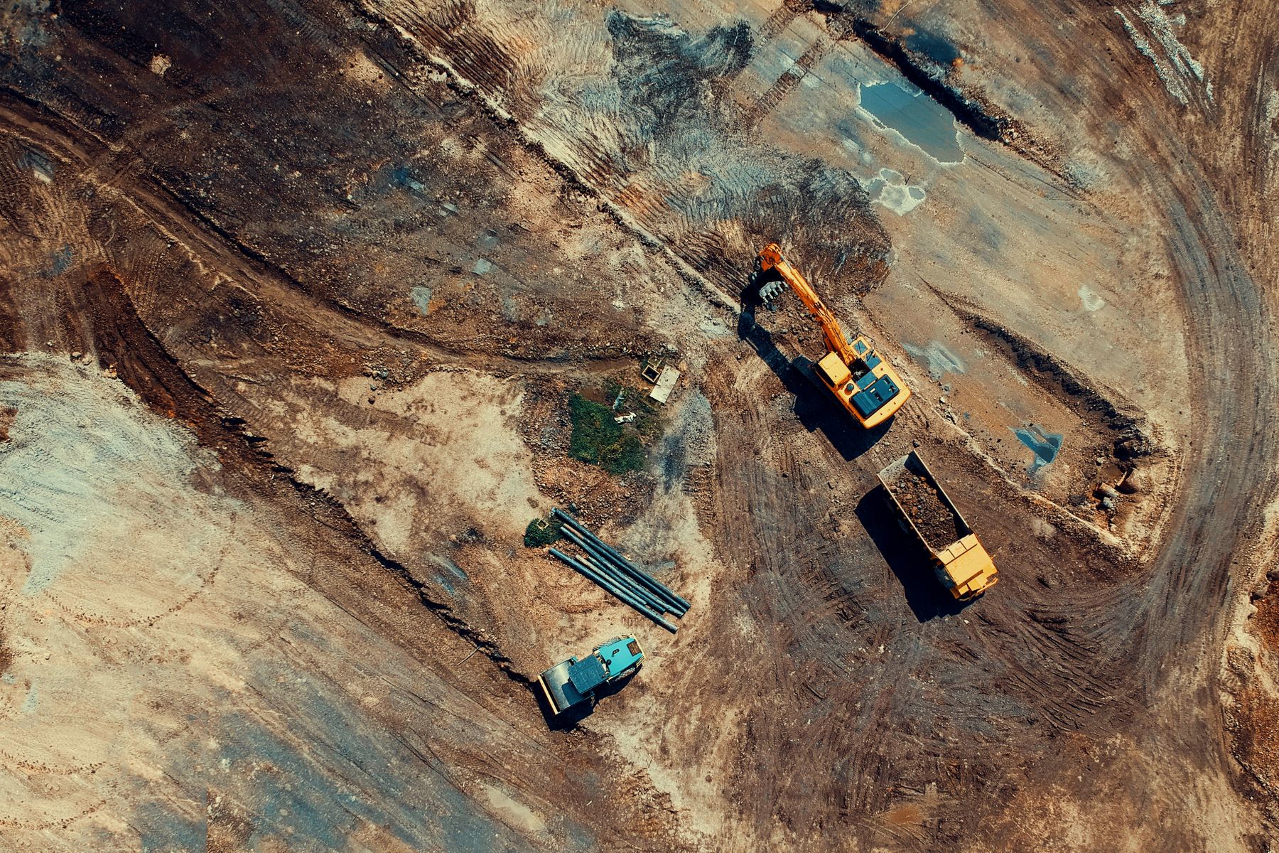 Aerial view of excavators and trucks working on an earthworks site