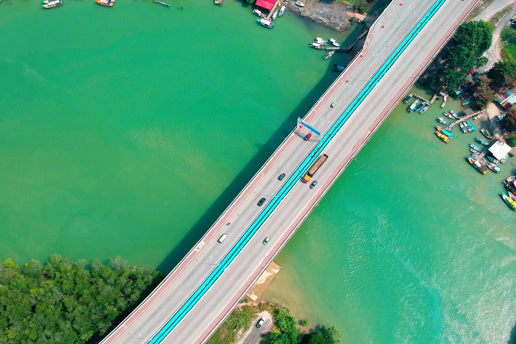 Aerial view of a road bridge crossing a turquoise river